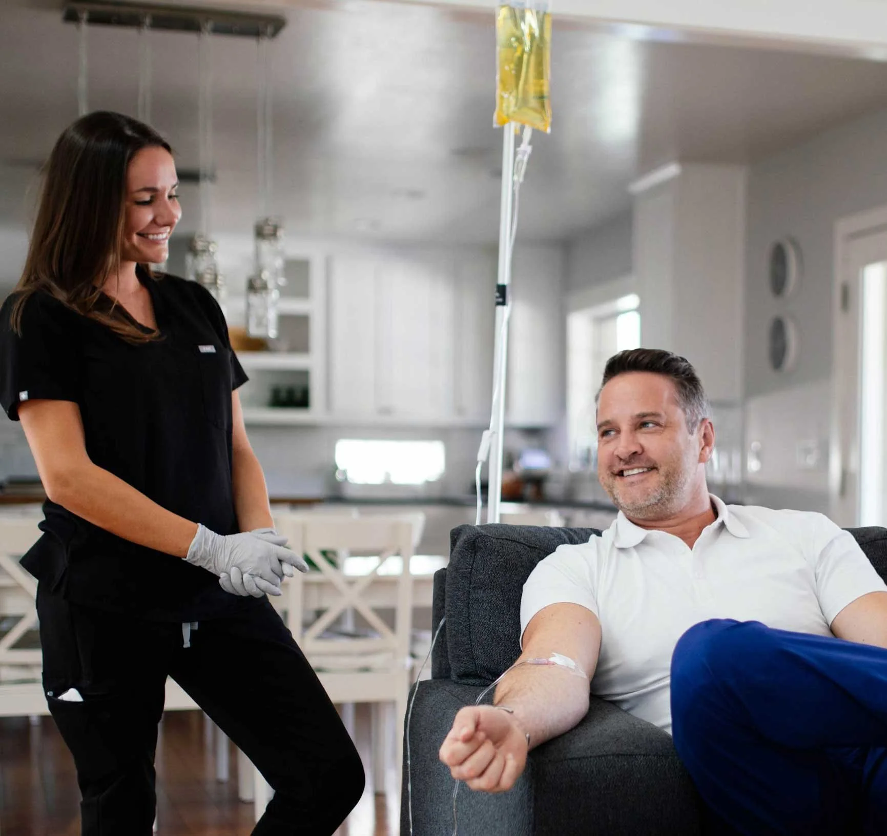 A registered nurse starting an IV infusion for a patient at home